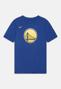 Camiseta de algodón azul con un gráfico redondo que muestra un puente en amarillo, rodeado por un fondo circular amarillo. Logo de Nike en la manga.
