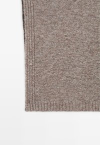 Bruine ribgebreide stof met een zachte textuur, met verticale groeven. Een gelijkmatige kleur over de gehele stof met een licht fuzzy uiterlijk.
