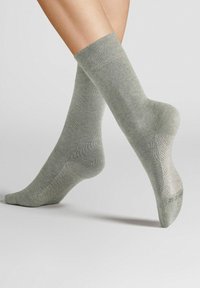 Light green socks featuring a ribbed top, smooth texture, and reinforced heel and toe with a subtle pattern on the foot.