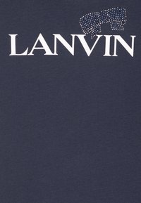Granatowa bawełniana koszulka z nadrukiem "LANVIN" w białych literach, z niebieskim akcentem w postaci kryształków dookoła zwierzęcego wzoru nad napisem.