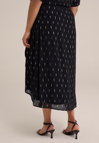 Musta poimuhelma, jossa on kultaiset foliokoristeet, keskipitkä, sisältää ilmavan muotoilun ja sivuhalkion. Yhdistetty mustiin hihnallisiin korkokenkiin.