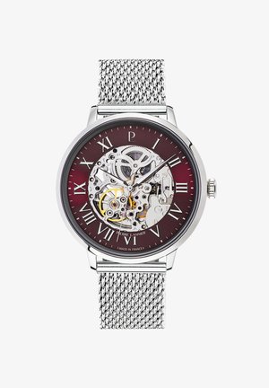 Strieborný hodinky s burgundským ciferníkom, ktorý zobrazuje kostru. Rímske číslice označujú hodiny. Kovový sieťový remienok. Vyrobené vo Francúzsku.