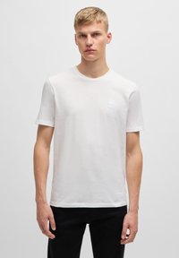 Witte korte mouwen t-shirt van lichtgewicht materiaal, met een ronde hals en een klein merkembleem op de borst.