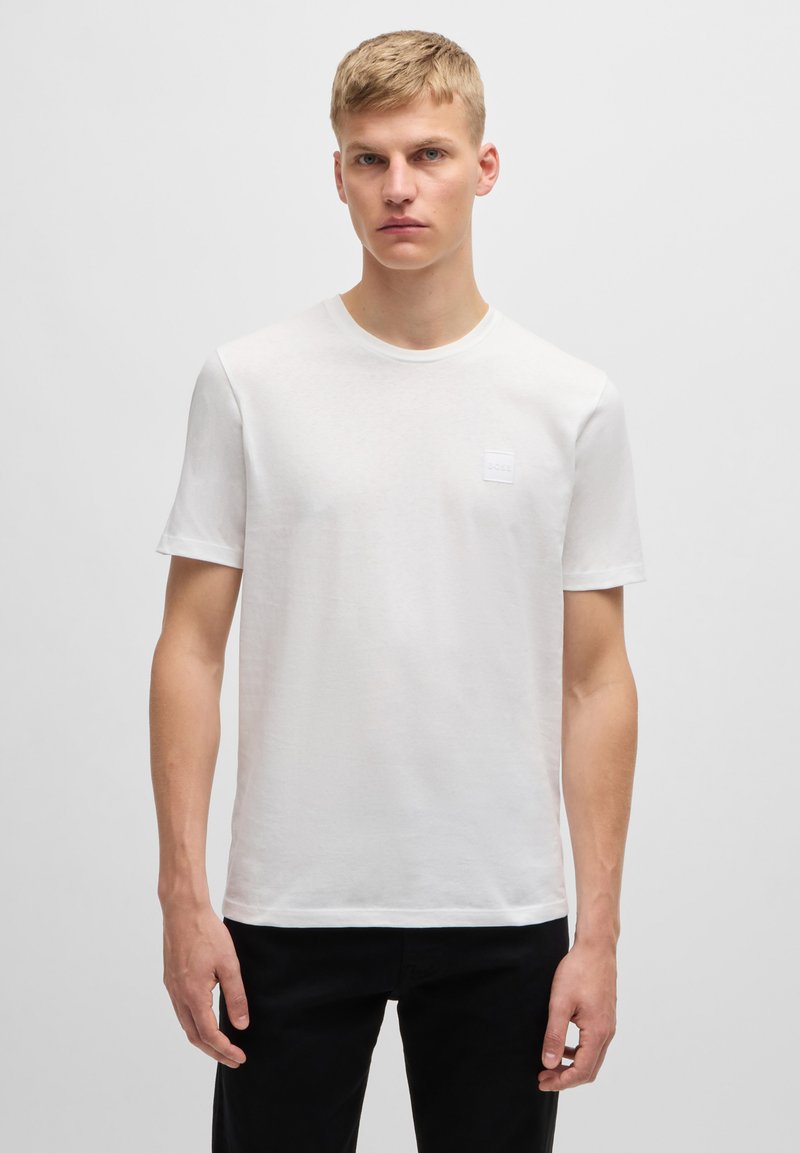 Witte korte mouwen t-shirt van lichtgewicht materiaal, met een ronde hals en een klein merkembleem op de borst.