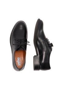 Zwarte leren veterschoenen met ronde neuzen, lage hakken en bruine binnenzolen met het merk "usha BLUE LABEL."