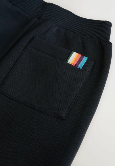 Námornícke tepláky s rebrovaným pásom a zadnou kapsou s viacfarebnou prúžkovanou etikettou. Mäkká, štruktúrovaná tkanina.