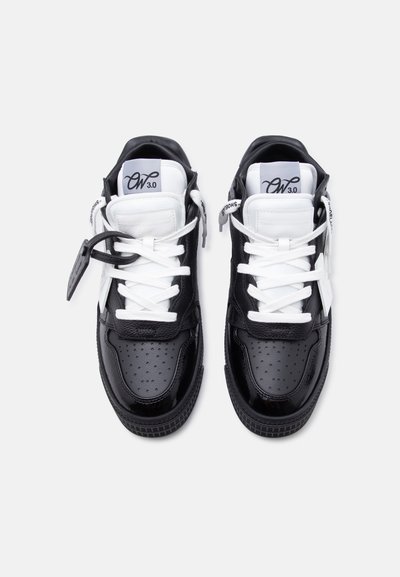 Ζευγάρι ασπρόμαυρα ψηλά αθλητικά παπούτσια με λευκά κορδόνια, διάτρητα μπατζάκια στα δάχτυλα και ετικέτες "OW 3.0" στις επενδυμένες γλώσσες.