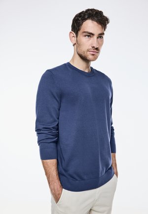 Navy blue crew-neck sweater, knitted fabric, long sleeves with ribbed cuffs, featuring a relaxed fit and minimal design details.