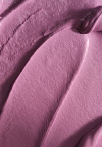 Texture cremosa viola con motivi lisci e ondulati e una leggera lucentezza; appare densa e ricca, indicando una sostanza morbida e spalmabile.