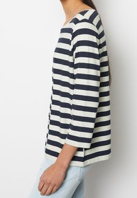 Randig skjorta i marinblått och off-white, med 3/4-långa ärmar och en avslappnad passform. Mjuk tyg med rundad halsringning och sidofickor.