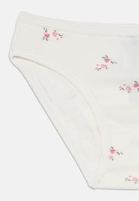 Bomullsshortser i off-white med små rosa blomster mønster. Har delikat søm langs midjebåndet og benåpningene.