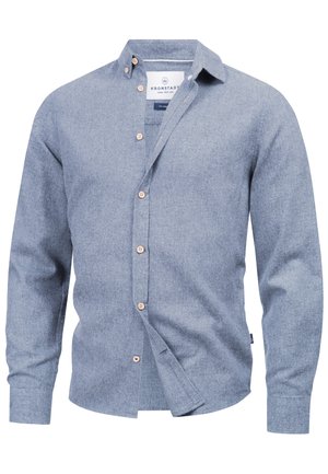 Lyseblå skjorte med knappet front, laget av teksturert stoff. Har spiss krage og treknapper langs fronten. Lange ermer.