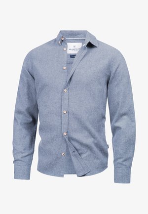 Lyseblå skjorte med knappet front, laget av teksturert stoff. Har spiss krage og treknapper langs fronten. Lange ermer.