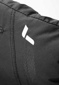 Zwarte stof met zichtbare stiksels. Bevat een wit logo en subtiele, gestructureerde lijnen die een patroon op het oppervlak van de stof creëren.