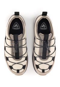 Beige Sport Schuhe mit strukturiertem Obermaterial, schwarzen elastischen Schnürsenkeln, einer Zuglasche und einer grauen Gummisohle. Entwickelt für Komfort und Unterstützung.
