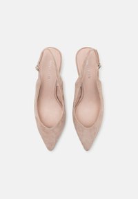 Nude mokkanahka slingback -kengät, joissa on terävä kärki ja säädettävä nilkkavö. Siisti pinta ja minimalistinen muotoilu, brändin nimi sisällä.