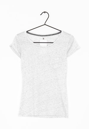 Lichtgrijs T-shirt met korte mouwen en ronde hals, met een klein borstzakje, hangend aan een zwarte draadhanger tegen een witte achtergrond.