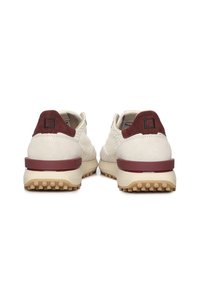 Zapatos beige con detalles burdeos, parte superior de ante y textil, suela de goma y un detalle de logo cuadrado en el talón. La textura es suave.