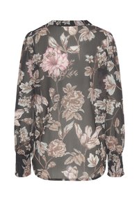 Blusa nera trasparente con motivi floreali in rosa e blu. Maniche lunghe con polsi arricciati. Tessuto leggero e fluente. Collo rotondo.