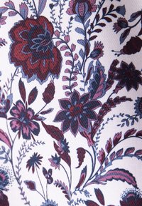 Motif de tissu floral avec de grandes et petites fleurs dans des nuances de rouge foncé, rose, bleu et violet sur fond blanc.