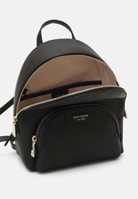 Zwarte leren Kate Spade New York mini rugzak met gouden ritsen en beige stoffen binnenvoering, voorzak met ritssluiting gedeeltelijk open.