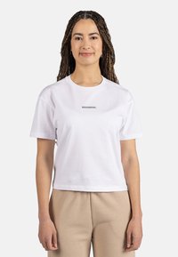 Camiseta de algodón blanca con mangas cortas, cuello redondo y logo gris "ROSSIGNOL" centrado en el pecho. Ajuste casual, textura suave.