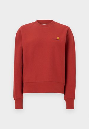 Rød crewneck-genser med lange ermer og ribbede mansjetter, med en liten gul og svart Carhartt-logo på venstre bryst.