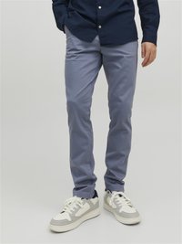 Helles blaues Slim-Fit-Hosen aus Baumwollmischung, mit einer glatten Textur und kombiniert mit weißen und grauen Sneakers.