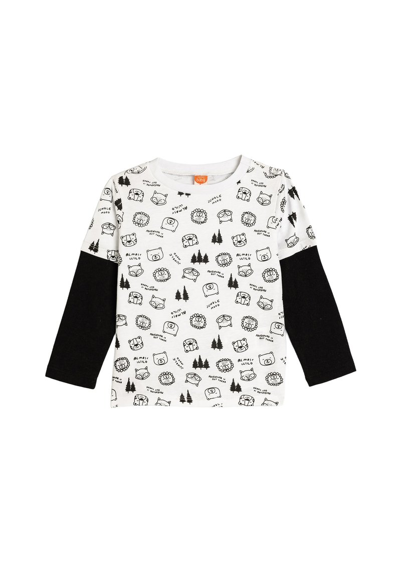 Langärmliges Shirt aus einem weißen Stoff mit schwarzen Tier- und Baumdrucks, ergänzt durch schwarze Ärmel. Runder Ausschnitt.