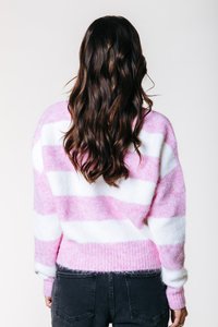 Pull surdimensionné, rayé rose et blanc, texture douce, poignets et ourlet côtelés, coupe décontractée, porté avec un jean foncé.