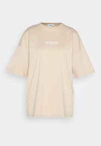 Beige oversized t-shirt lavet af bomuld, med korte ærmer og rund halsudskæring. På forsiden står der "PACIFIC COAST California" i hvid.