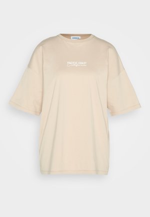 Beige oversized t-shirt made of cotton, featuring short sleeves and a round neckline. Front has "PACIFIC COAST California" text in white.