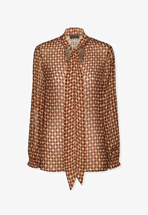 Transparante bruine blouse met een strik-kraag, voorzien van een geometrisch patroon van licht- en donkerbruine stippen. Lange mouwen met elastische manchetten.