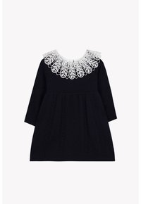 Robe longue noire en maille à manches longues avec des motifs torsadés et un large col en dentelle blanche comportant des motifs floraux complexes.