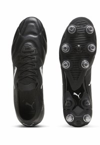 Czarne korki piłkarskie z teksturowaną syntetyczną cholewką, z wiązaniem na sznurówki i białymi akcentami logo, uwydatnione przez skonstruowaną podeszwę dla lepszej przyczepności.