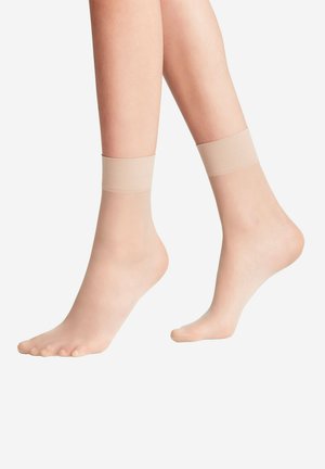 Nude skarpetki kostkowe wykonane z przezroczystego, miękkiego materiału z gładką, elastyczną gumką u góry, zapewniającą komfortowe dopasowanie, częściowo zakrywające stopę.