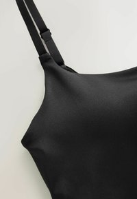 Sort bh med glat stof, justerbare stropper, kontureret form og minimalistisk design, der har en sømløs konstruktion.