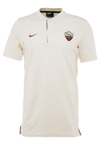 Kremowa koszulka polo z zapięciem na guziki przy kołnierzyku. Posiada bordowe logo Nike oraz herb Romy na lewej piersi. Gładki materiał z bocznymi akcentami.
