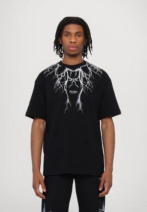 T-shirt in cotone nero con una grafica di un fulmine bianco sulla parte anteriore e il testo "PHOBIA" centrato sotto il design. Maniche corte.
