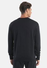 Schwarzer Crewneck-Sweatshirt mit langen Ärmeln, aus weichem Stoff hergestellt. Mit einem gerippten Kragen und Bündchen sowie einem schlichten, klaren Design.