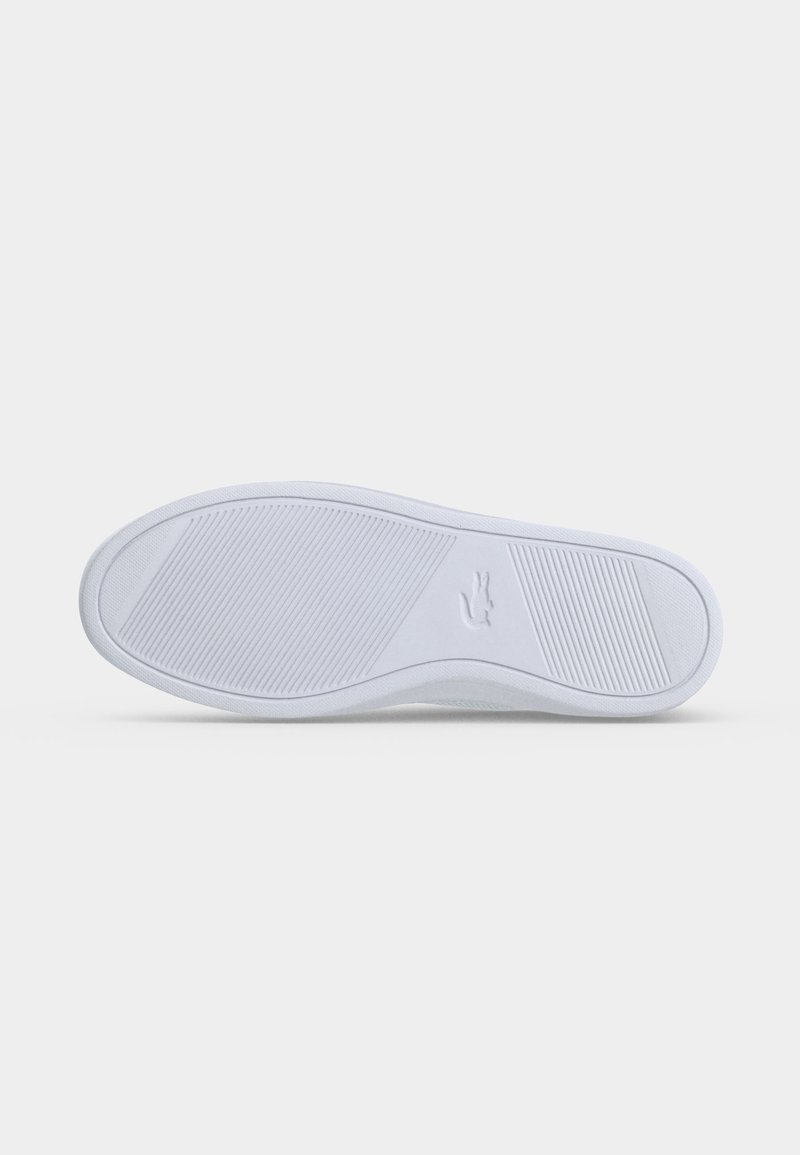 Weiße Sneaker-Sohle mit strukturierten Griffmustern und einem kleinen geprägten Krokodil-Logo im mittleren Bereich.