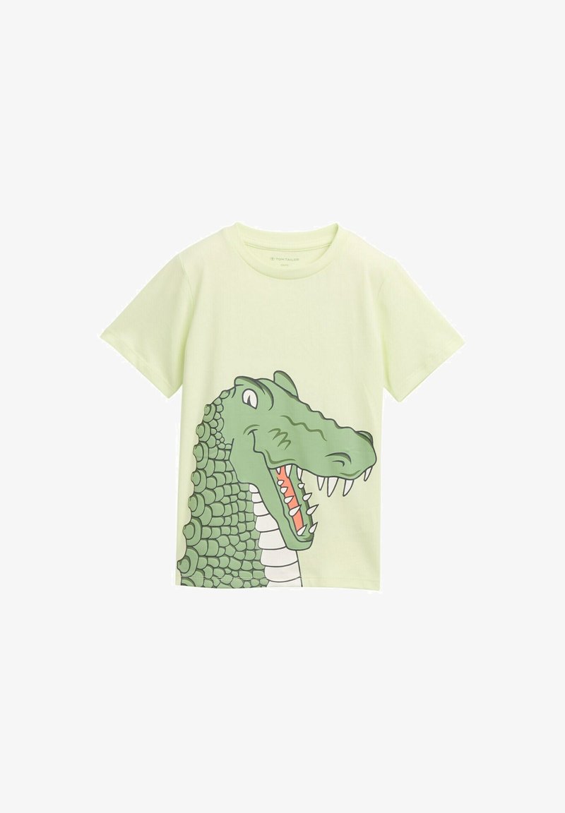Camiseta de algodón verde claro con un gran gráfico de cocodrilo en la parte frontal, con escamas detalladas, dientes blancos y acentos naranjas.