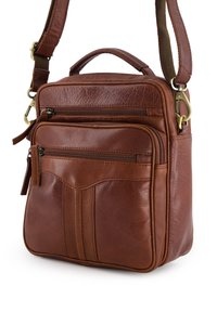Sac en cuir brun porté croisé avec deux poches zippées à l'avant, une poignée supérieure et une sangle amovible ; surface texturée avec des coutures subtiles.