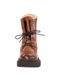 Bota de tobillo de cuero marrón con cordones, punta redonda, suela texturizada y forro suave. Presenta cordones oscuros y una marca mínima en la lengua.