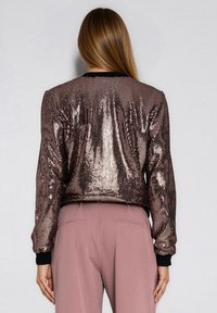 Błyszcząca kurtka bomberka o krótkim kroju, w kolorze różowego złota, z prążkowanymi mankietami i gładką fakturą.