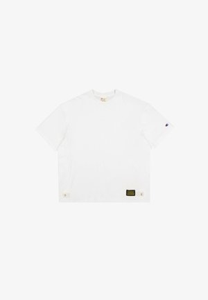 T-shirt en coton blanc avec un col rond, des manches courtes et une étiquette en bas à gauche avec un texte noir sur fond jaune.