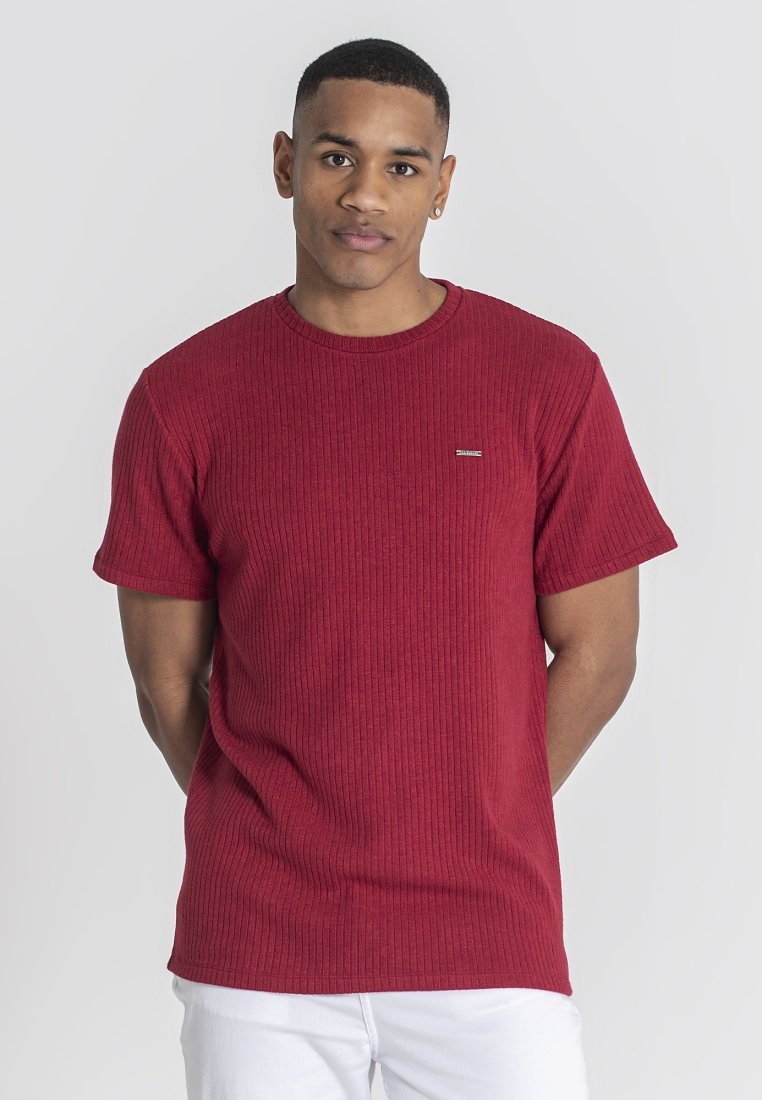 Röd ribbad kortärmad t-shirt med rund hals. Har en liten logotyp på vänster sida. Tillverkad av strukturerat tyg, figurnära passform.