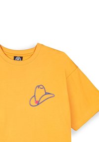 Camiseta de algodón amarilla con un diseño bordado de un sombrero vaquero azul y rojo en la zona del pecho izquierdo, con un cuello redondo y mangas cortas.