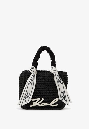 Fekete szövött kézitáska összegyűrt fekete fogóval és fehér selyem masni díszítéssel, elöl fehér, írott "Karl" logóval.