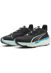 Zwarte sportieve schoenen met een gestructureerde mesh bovenkant, witte accenten, lichtblauwe tussenzool en zwarte rubberen loopzool. Ontworpen voor comfort en ondersteuning.